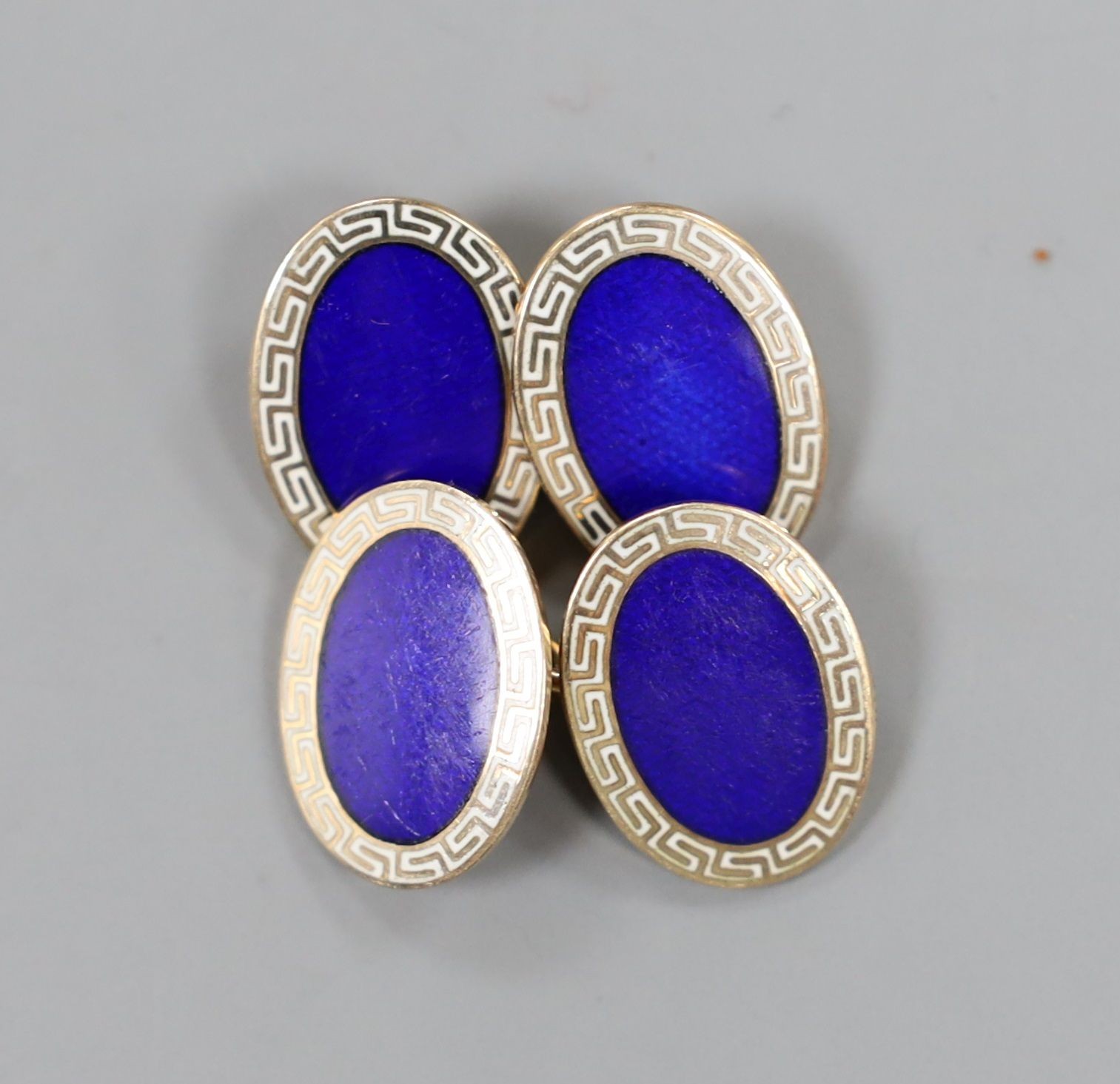 A modern pair of 9ct gold and two colour enamel set oval cufflinks, with Greek key border, 18mm, gross weight 10.5 grams.